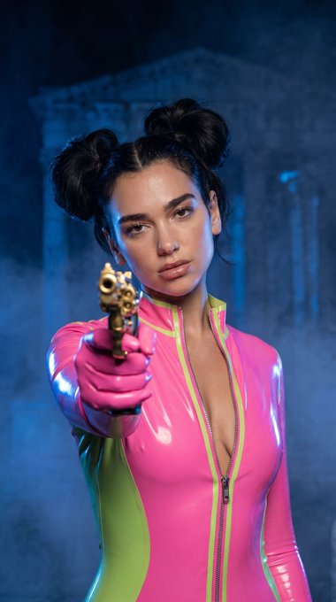 Curvaceous model with glossy lips and neon pink latex bodysuit, holding a golden revolver in a deep blue-lit ancient setting.