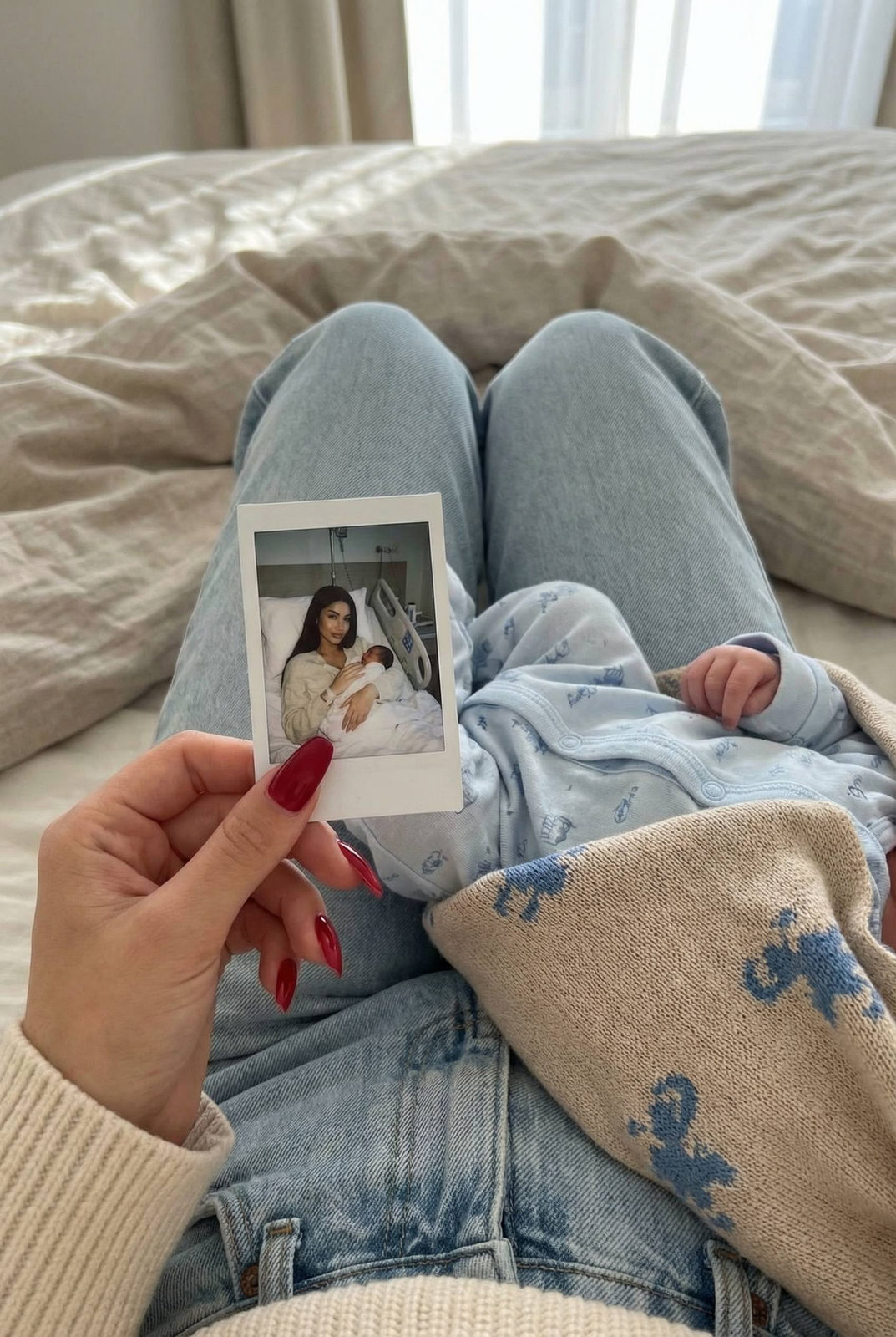 Bed Holding Polaroid Baby On Lap