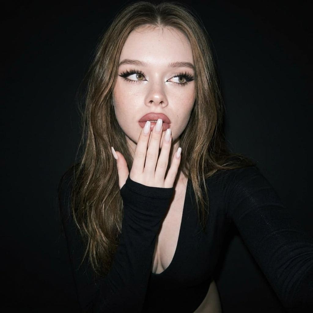 A photorealistic portrait of a person with a hand covering their lips in soft focus, highlighting expressive makeup and natural hair texture.