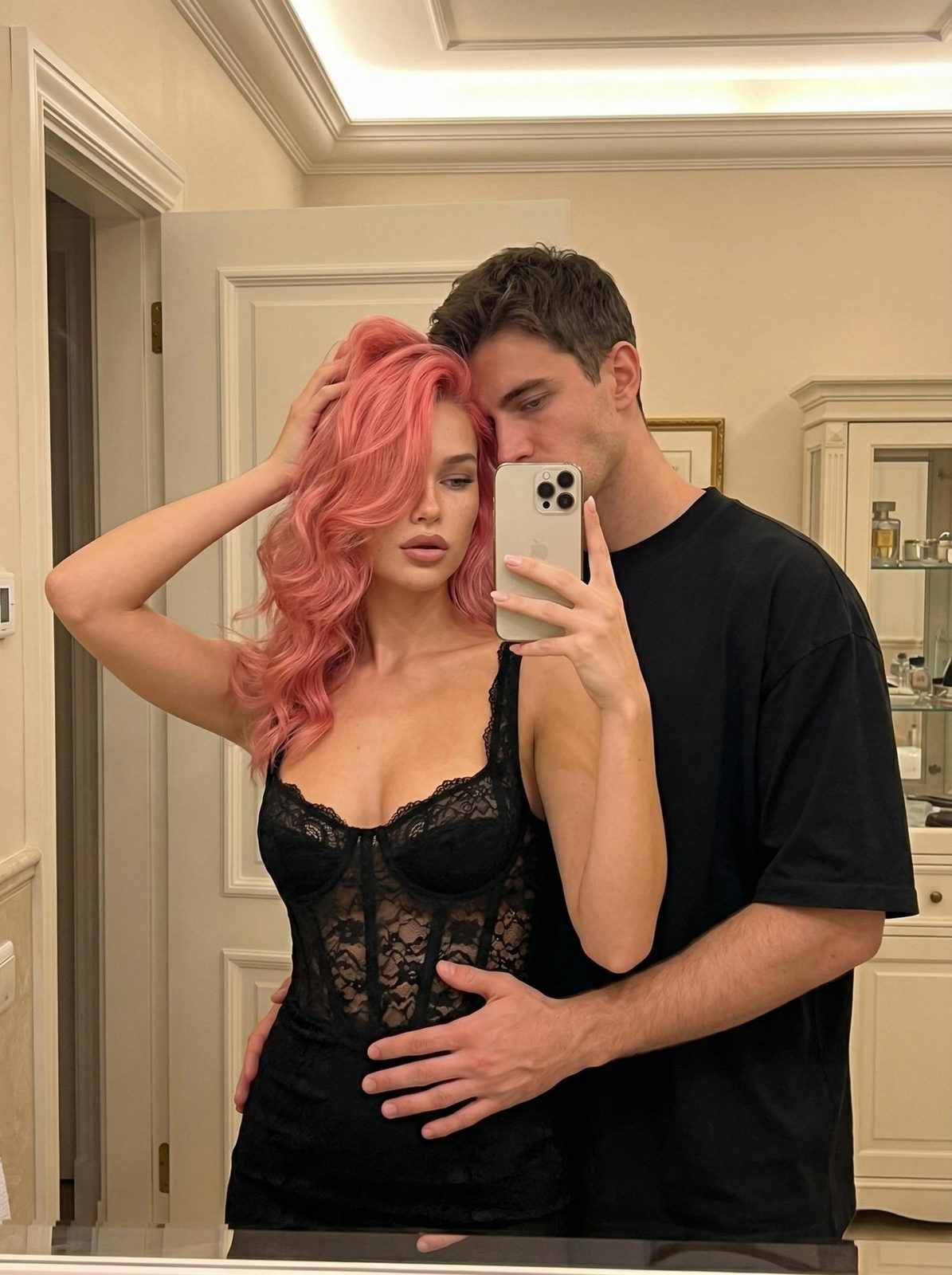 A couple in a bathroom, woman capturing her reflection on a phone, intimate pose with warm, soft lighting.