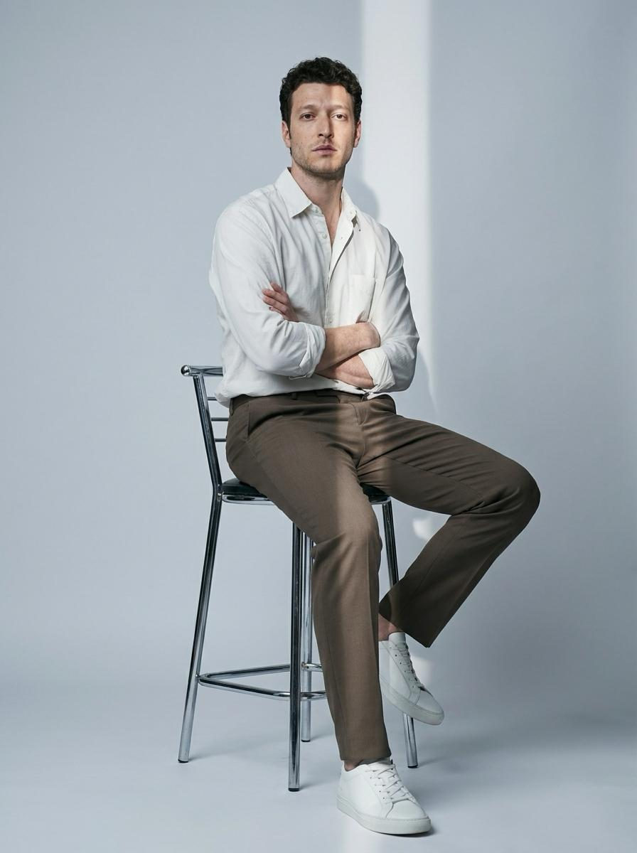 Seated On Bar Stool White Shirt Taupe Trousers
